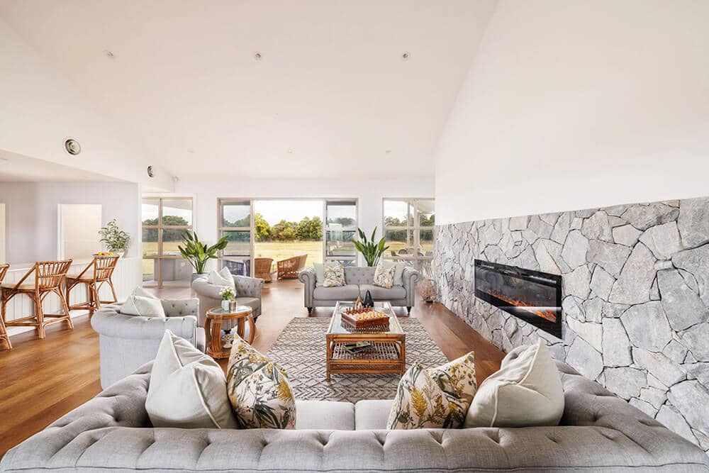 Sitting room with lounges, armchairs and a fireplace.