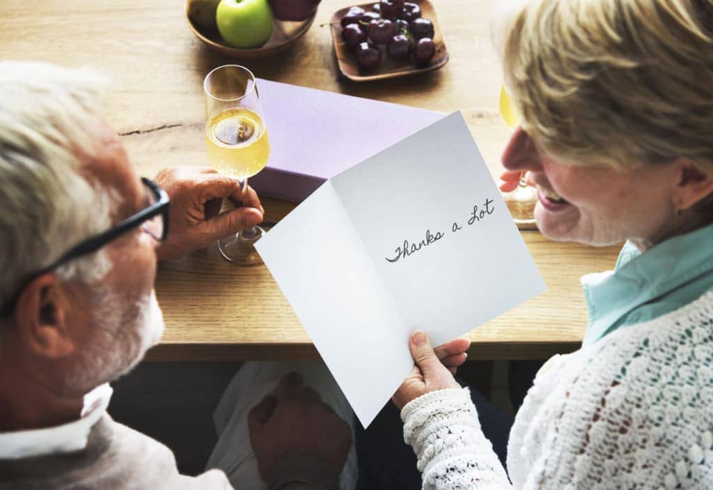 retiree couple reading a thank you card