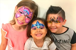 Three smiling children with their faces painted