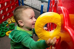 Toddler playing with toys and smiling