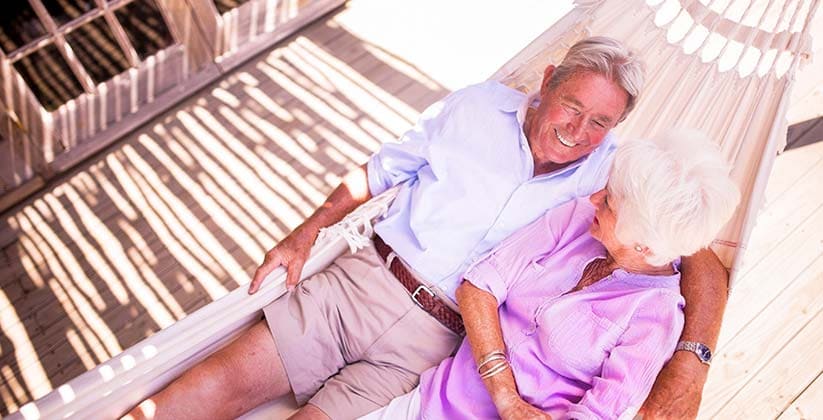 Elderly couple laying together in a hammock